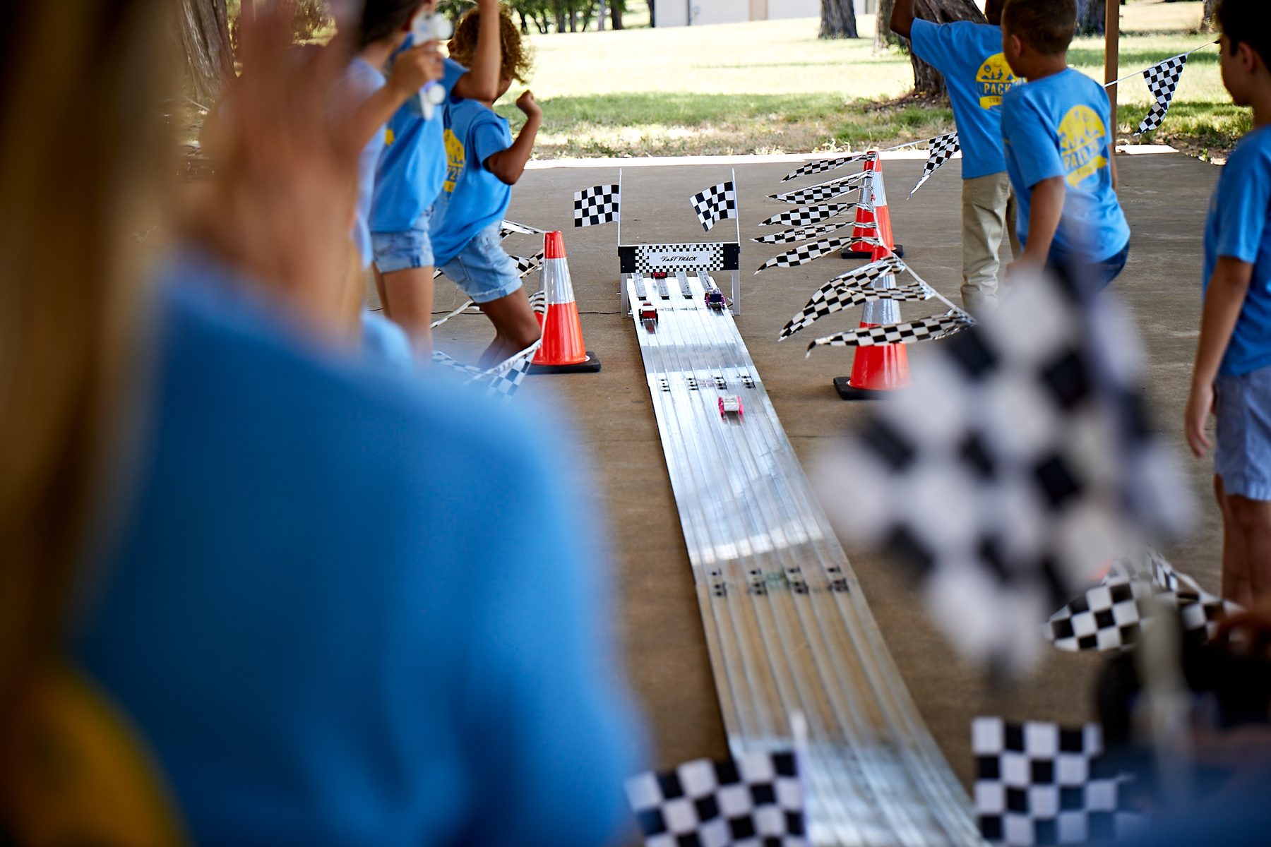 Pinewood Derby race track with Pack 818 scouts cheering in the background